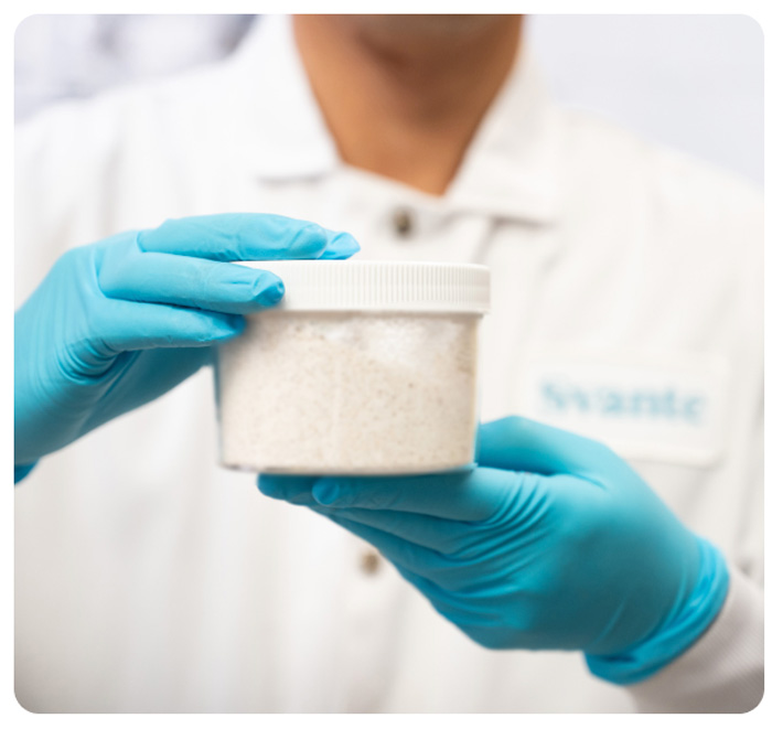 A scientist at Svante holding a jar of CALF-20, the company's metal-organic framework (MOF) for carbon capture and removal